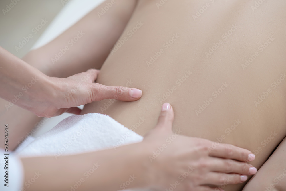 Close up picture of threpist hands massaging lower back Close up picture of threpist hands massaging lower back
