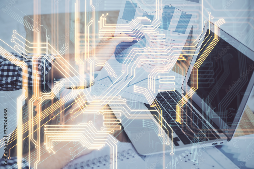 Obraz premium Technology theme hologram with man working on computer on background. High tech concept. Multi exposure.