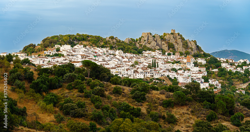 white spanish village landscape panoramic view with green bushes and cloudy sky