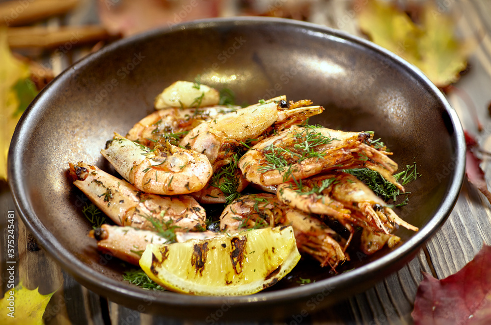 Fried prawns with lemon and dill are on a plate Fried prawns with lemon and dill are on a plate
