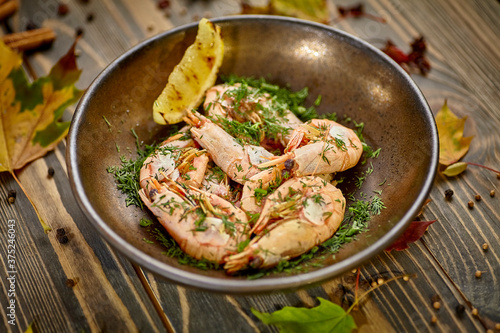 Boiled prawns with lemon and dill are on a plate