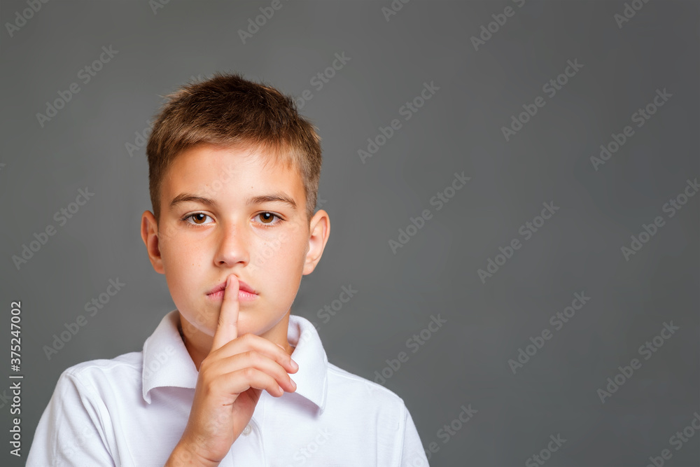 kid asking to be quiet with finger on lips. Copy space for text