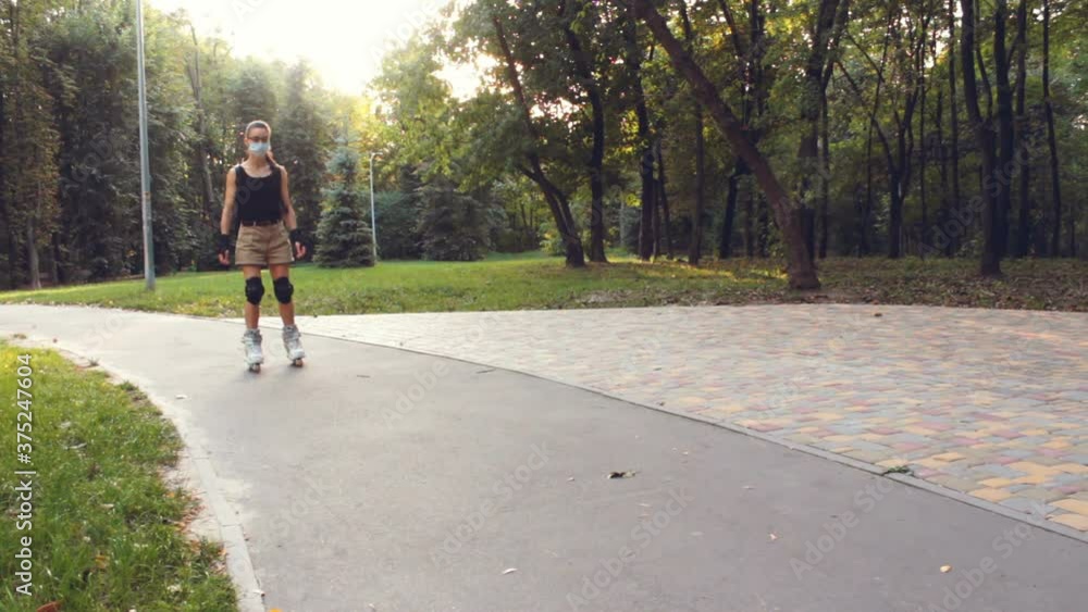 Young happy girl enjoy roller skating in the summer park. Young attractive girl is rollerblading in the park. Young happy girl enjoy roller skating in the summer park. Young attractive girl is rollerblading in the park.