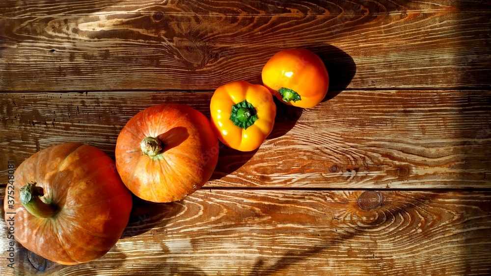 harvest time. Pumpkins, yellow peppers on wooden background. harvest time. Pumpkins, yellow peppers on wooden background.