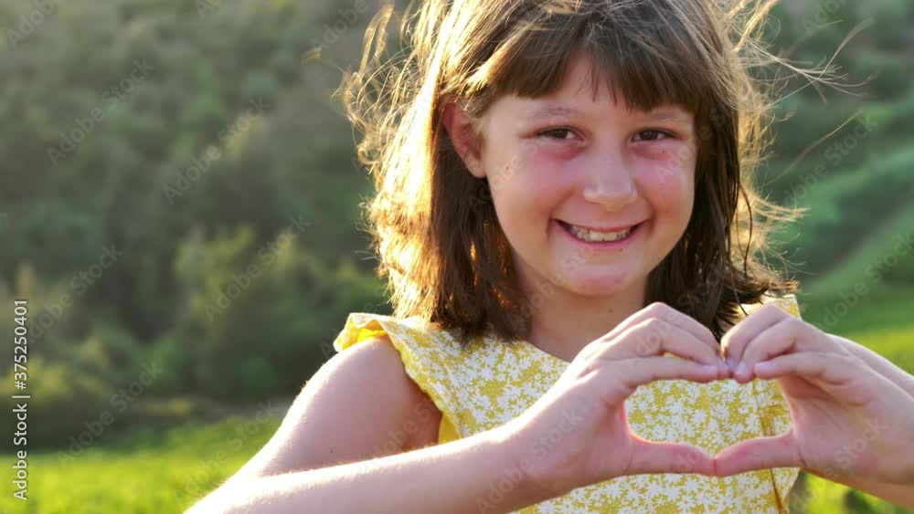 young smiling girl makes heart sign with her hands young smiling girl makes heart sign with her hands
