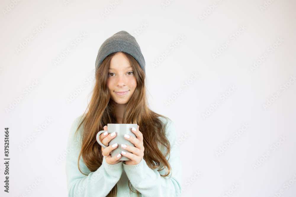 Smiling beautiful girl in winter clothes with a cup Smiling beautiful girl in winter clothes with a cup