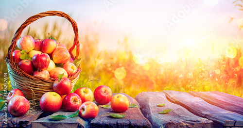 Red Apples In Basket On Aged Table With Defocused Sunset In Background - Fall And Harvest Concept
