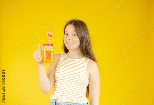 Smiling beautiful girl with long hair with a juice