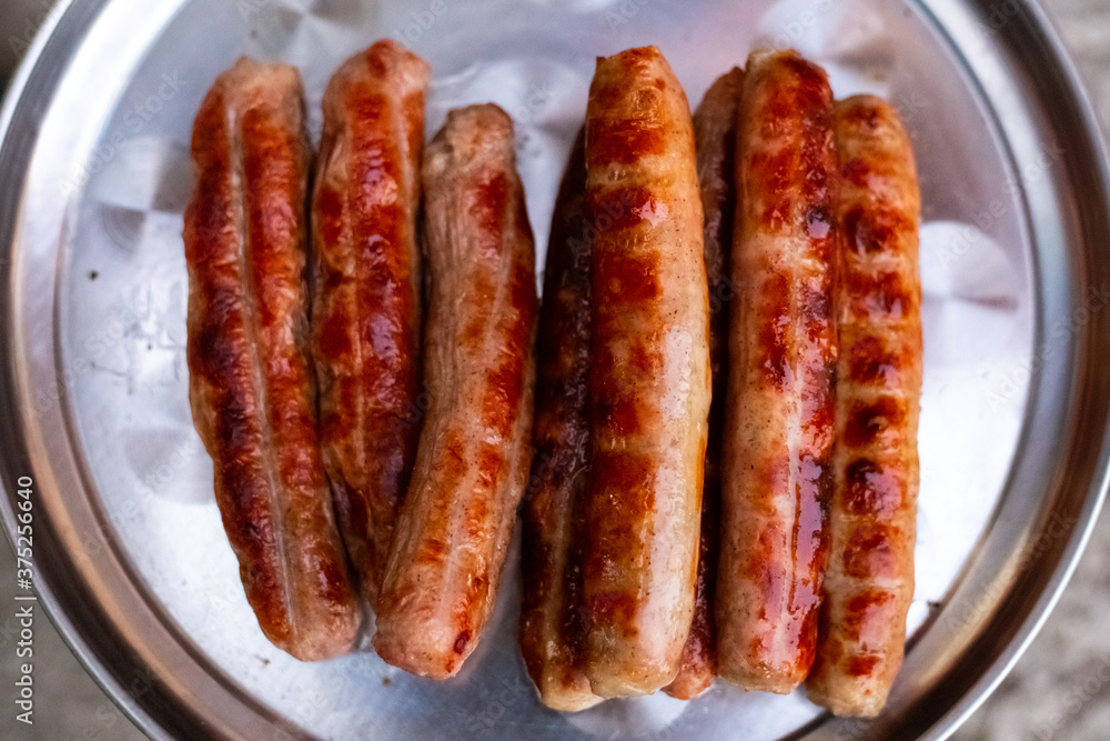 Delicious grilled meat sausages lie on an iron tray. Oktoberfest.