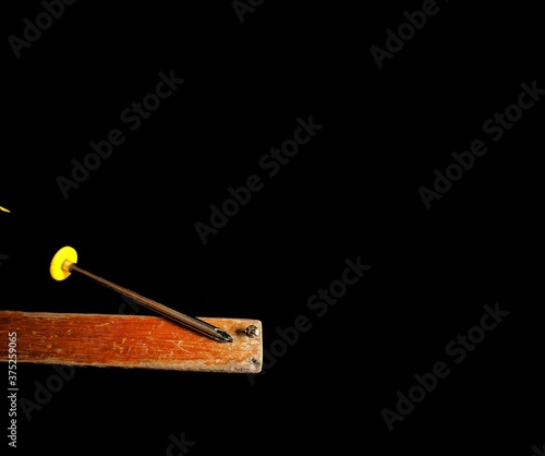 Wooden board with a screw and a screwdriver on black background. carpentry concept