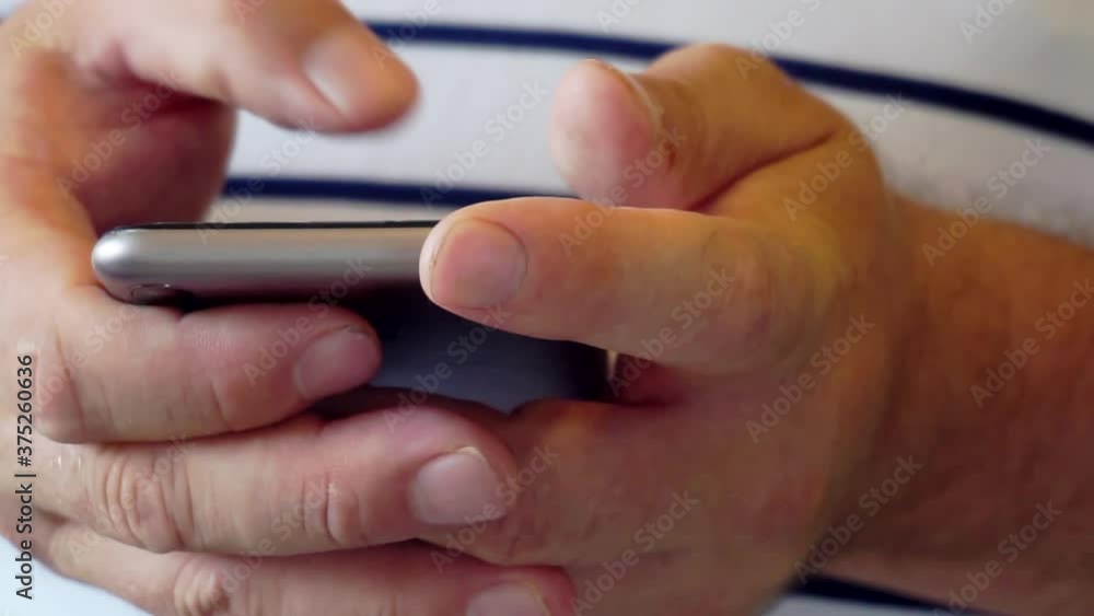 Hands of men using smartphone in the living room at home. Hands of men using smartphone in the living room at home.