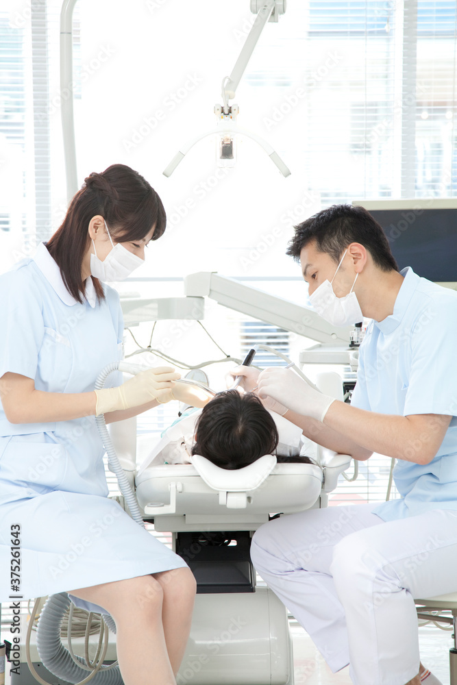 Obraz premium 治療する歯科医