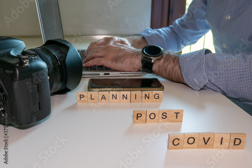 man plans photographic trip using laptop in post covid period photo