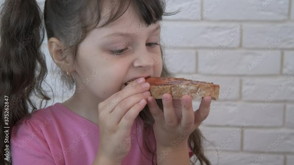 Eat bread with jam. A little girl eats bread with jam with pleasure. Eat bread with jam. A little girl eats bread with jam with pleasure.
