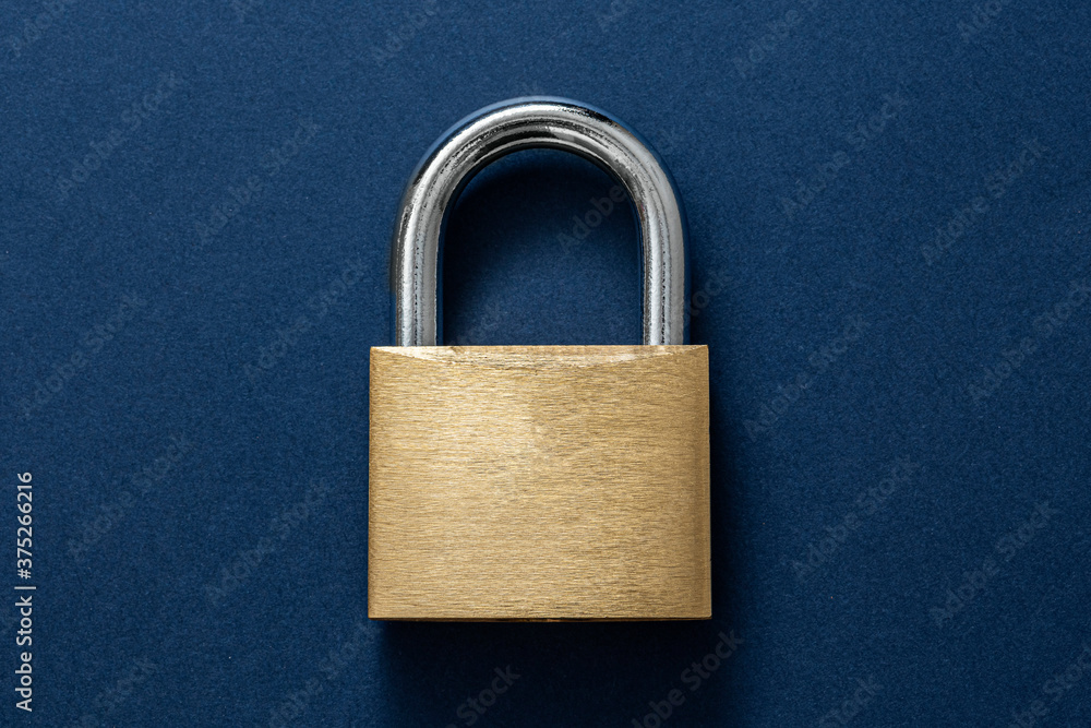 Fototapeta premium Locked Golden Padlock on the blue background.