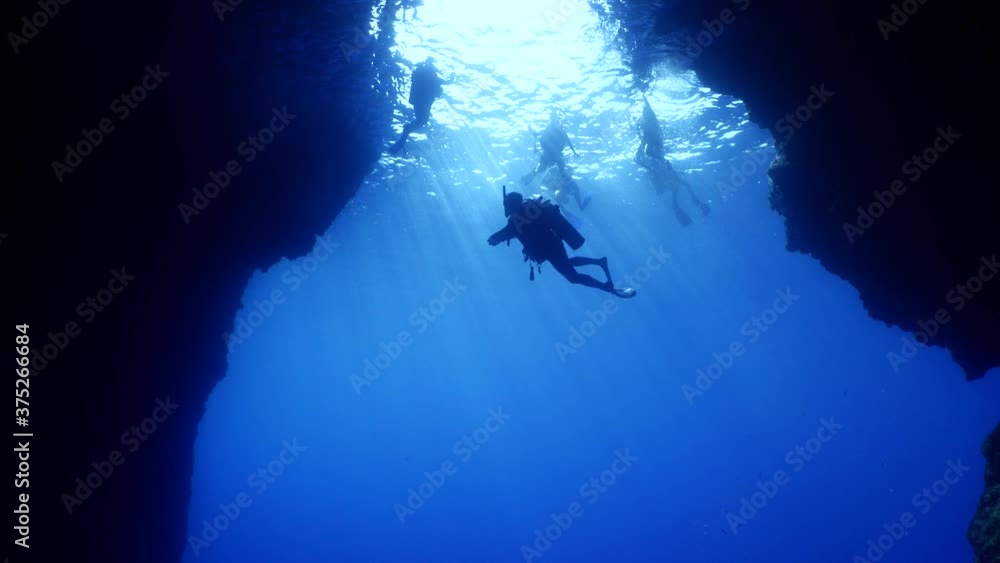 happy cave diving underwater scuba divers exploring caves ocean scenery sun beams and rays background happy cave diving underwater scuba divers exploring caves ocean scenery sun beams and rays background