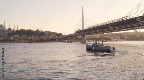 A boat in the Golden Horn Bay, behind the railway bridge the Rustem Pasha mosque