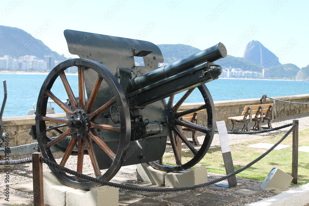 An old cannon, the sugar loaf mountain and the beach on background