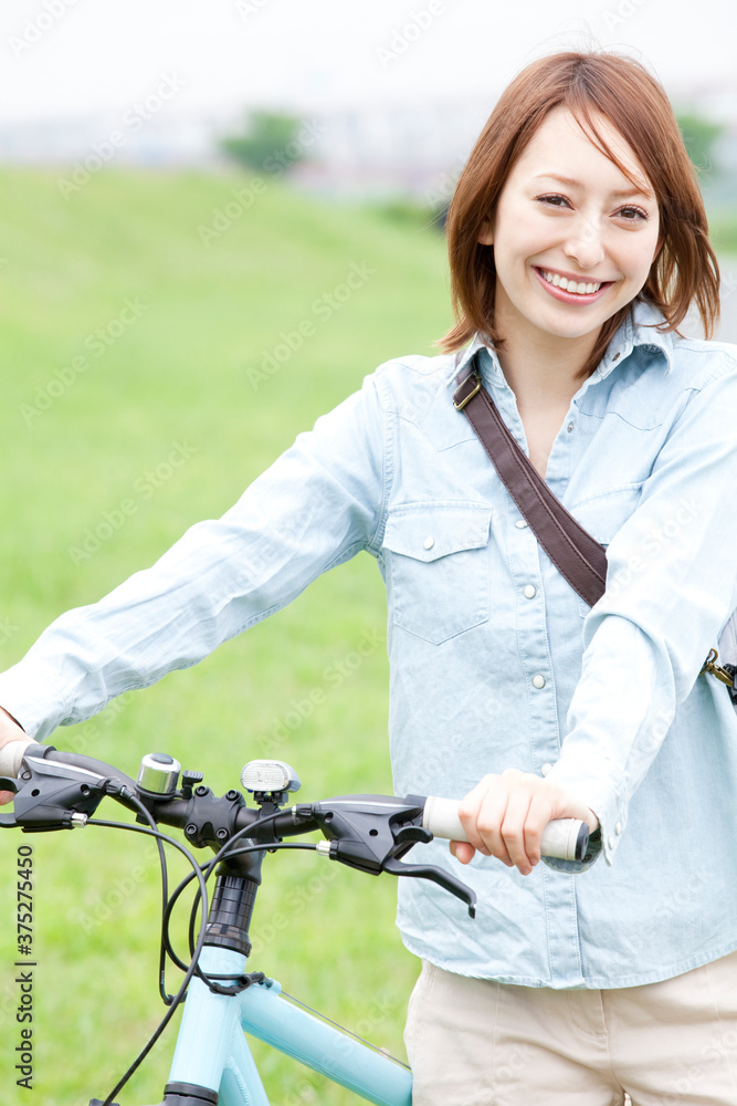 Obraz premium 自転車を押して歩く女性