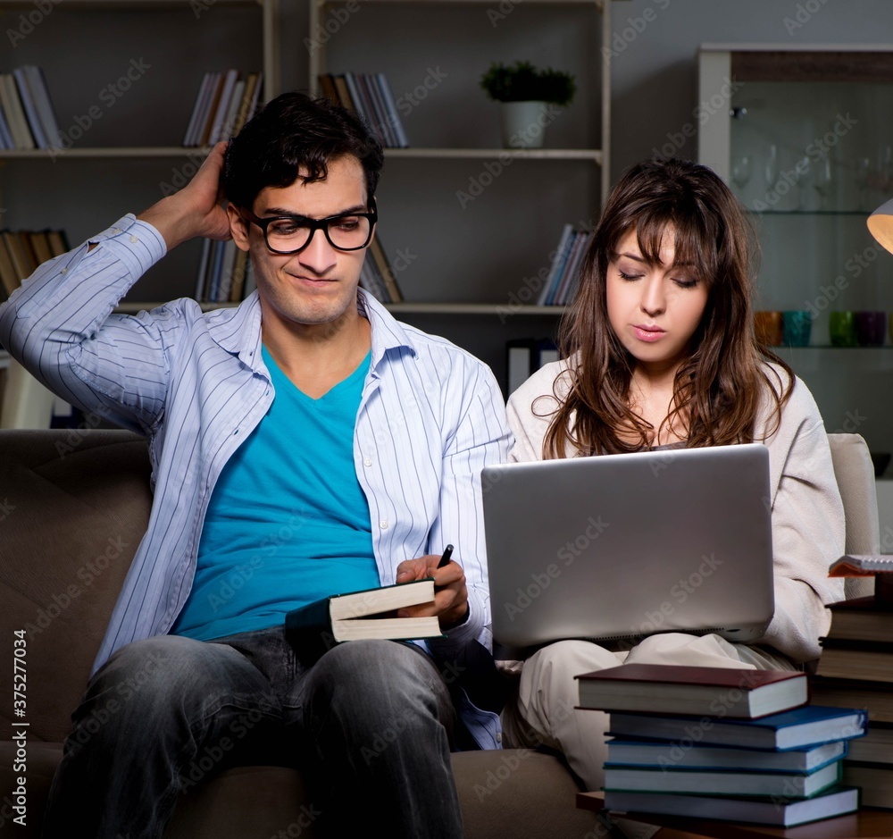 Two students studying late preparing for exams Two students studying late preparing for exams
