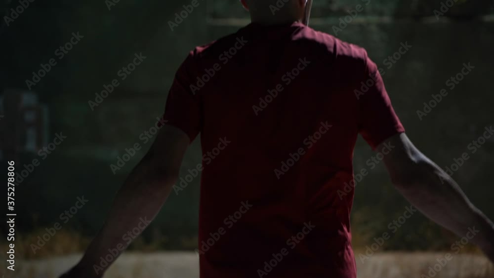 Boxer skipping rope at night on the street of a slum