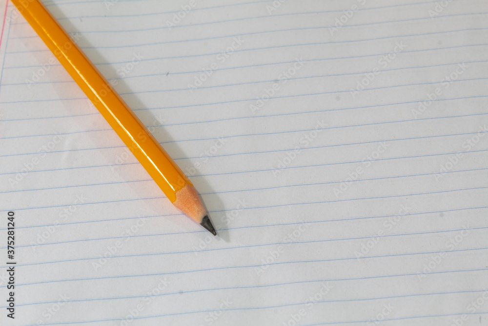 pencil on a blank sheet of notebook, concept of education and learning pencil on a blank sheet of notebook, concept of education and learning