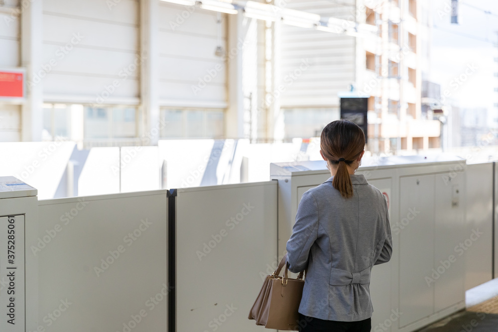 マスク姿で電車通勤をする女性 マスク姿で電車通勤をする女性