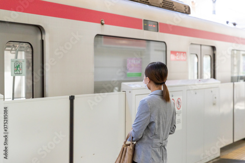 マスク姿で電車通勤をする女性