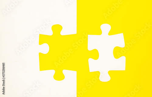 White puzzle pieces on a colored background top view.
