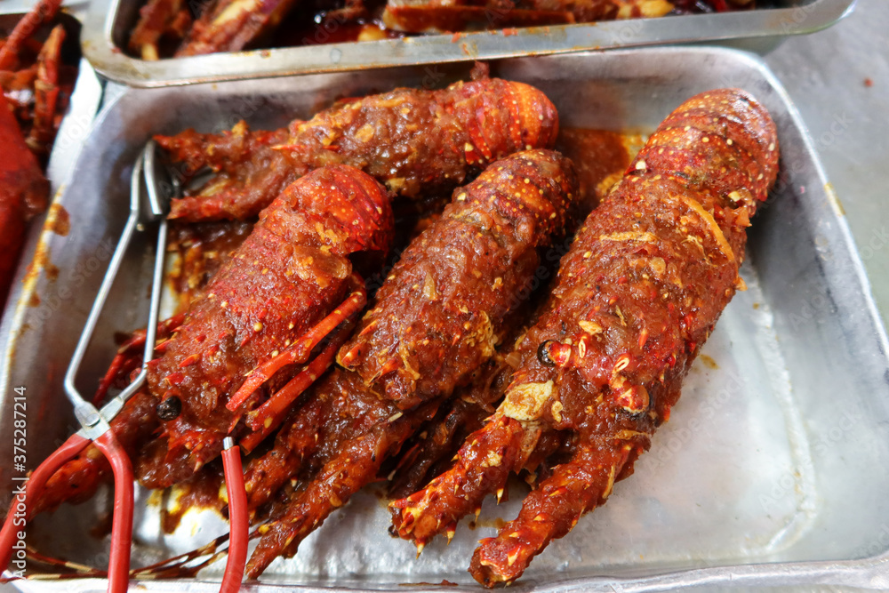 Georgetown, Penang, Malaysia, January 4, 2020: Lobsters with hot sauce at a prepared food stall at Pasar Lebuh Cecil Market in Georgetown, Malaysia.