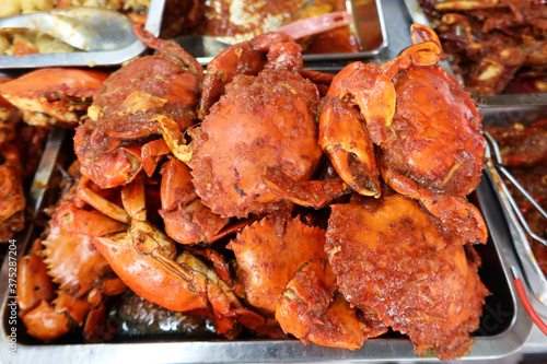 Georgetown, Penang, Malaysia, January 4, 2020: Crabs with sauce at a prepared food stall at Pasar Lebuh Cecil Market in Georgetown, Malaysia. photo