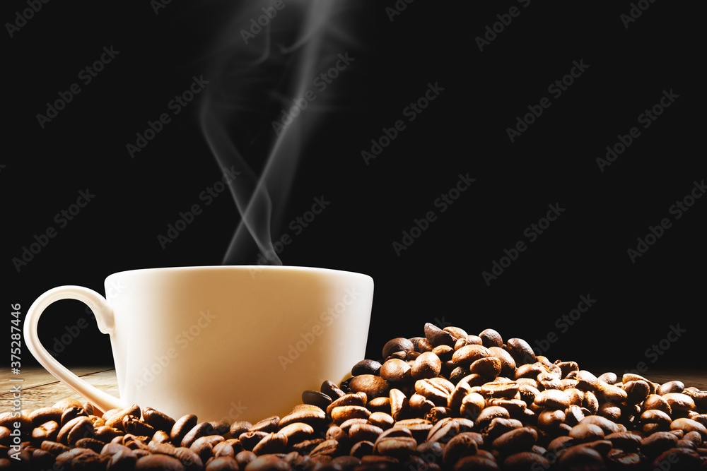 Cup of hot coffee with coffee beans on the table