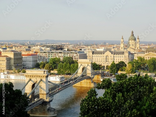 Panoramic view of Szechenyi Chain Bridge in Budapest city in the evening. Szechenyi Chain Bridge is a bridge cross over Danube river and connects Buda and Pest cities. © isparklinglife