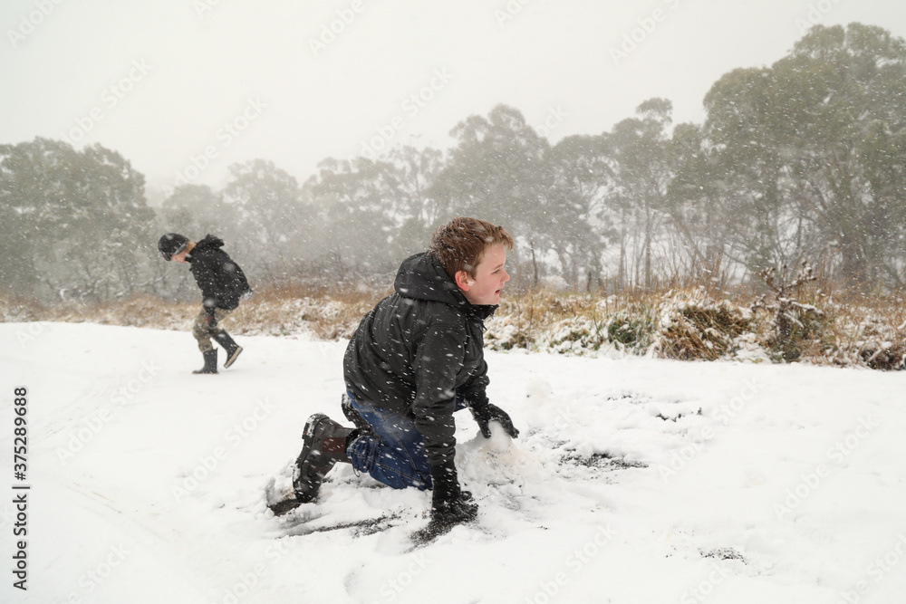 Happy boys playing in snow storm in New South Wales, Australia