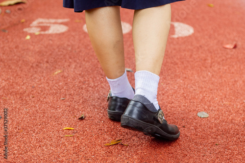 uniform shoes walking on red cement road