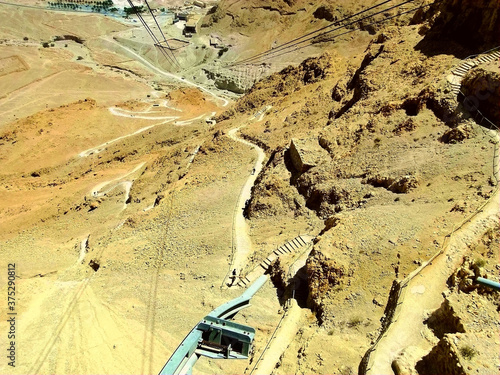 Aerial view of Masada foot path and cable car route from the top of hill. Masada is an UNESCO World Heritage Site in southern of Judea Desert in Israel. photo