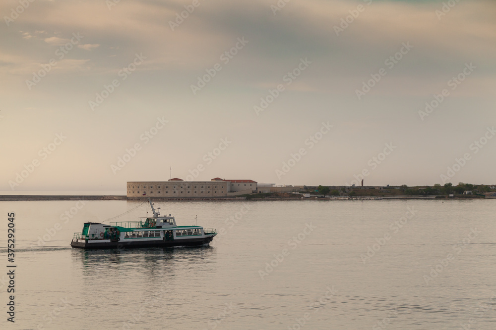 Passenger boat goes at Sevastopol bay at evening Passenger boat goes at Sevastopol bay at evening