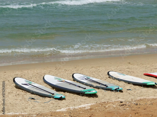 Surfing boards on sand beach. Surfing is a surface water pastime in which the wave rider. photo