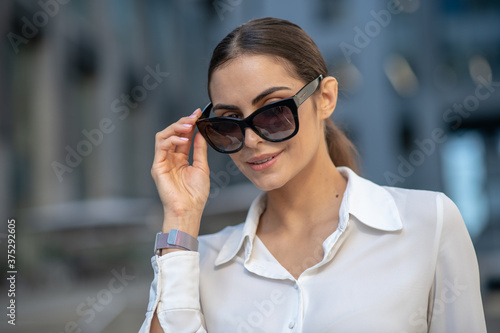 Pretty dark-haired stylish woman walking down the street