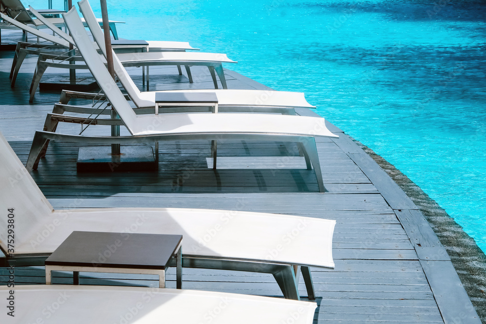 Many white chaise lounge by the pool