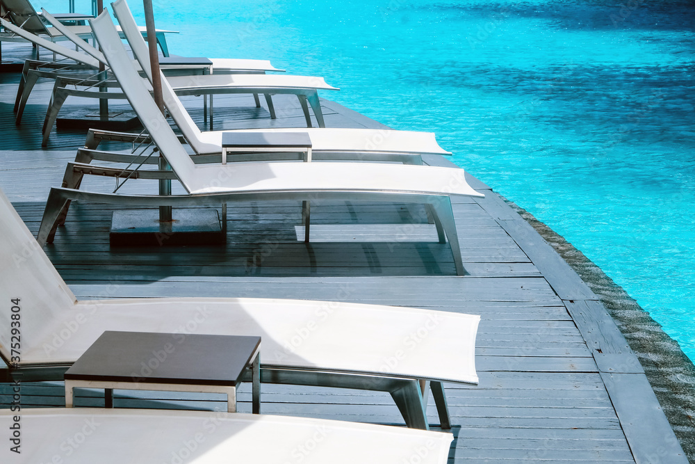 Fototapeta premium Many white chaise lounge by the pool