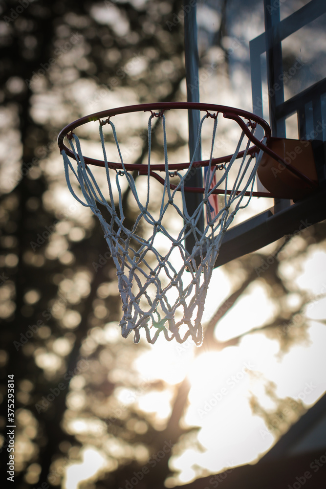 An unused basketball ring at sunset