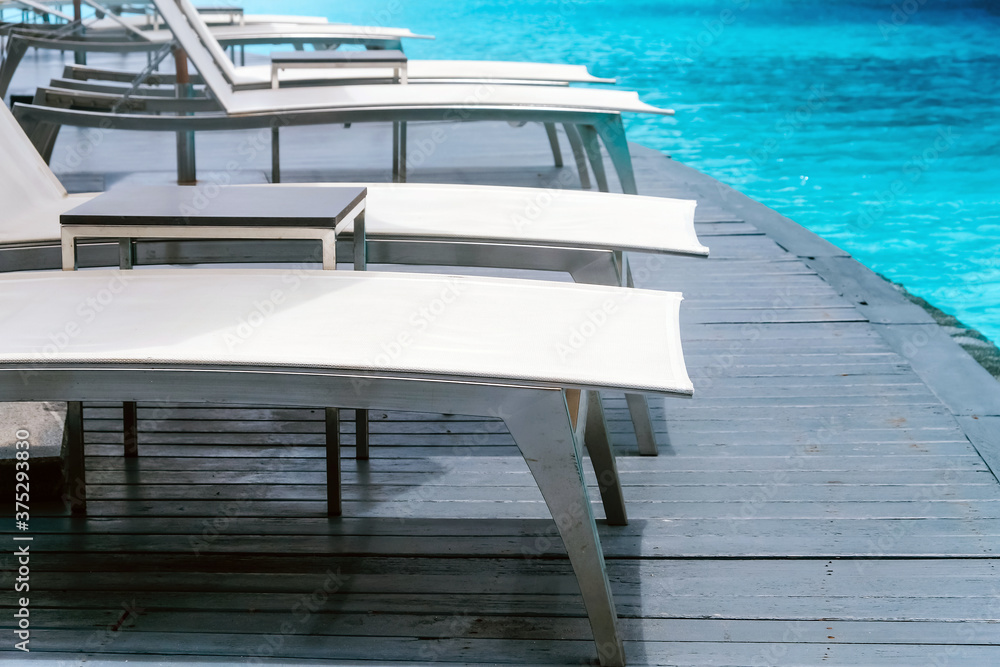 Fototapeta premium Many white chaise lounge by the pool
