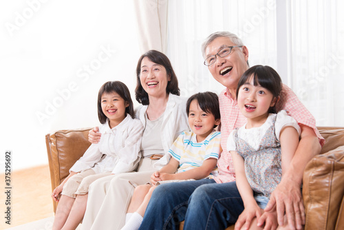 ソファに座る祖父母と孫 © Paylessimages