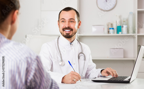 Positive man doctor with female visitor in hospital