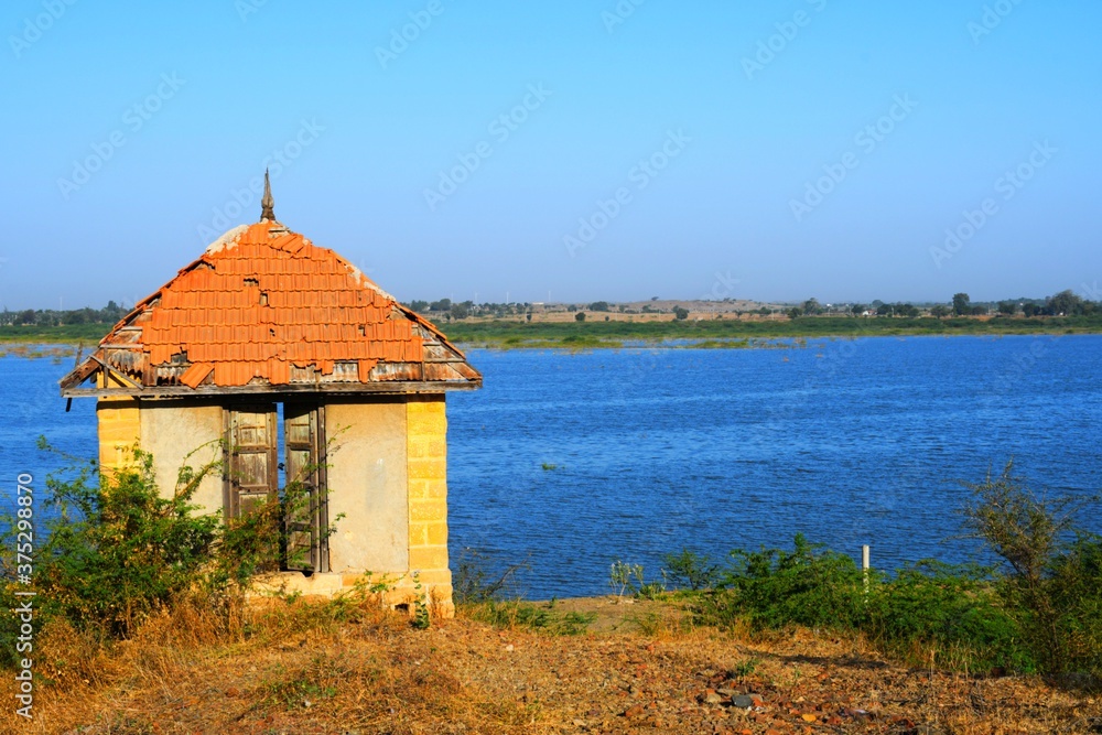 Hut on banks of the river of India, old hut, Little old house on banks of the river at sunset in silence Hut on banks of the river of India, old hut, Little old house on banks of the river at sunset in silence