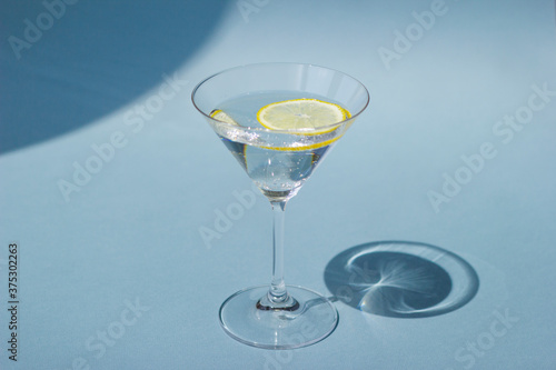 Cocktail with lemon. Trendy shadow concept.