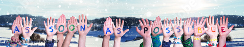 Children Hands Building Colorful English Word As Soon As Possible. Snowy Winter Background With Snowflakes