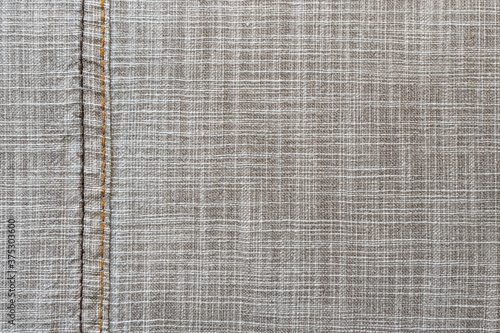 Linen fabric texture. Close-up. A fragment of linen cloth. Rough fabric texture. Double machine stitching on fabric. Decorative elements of trousers. Loose threads. A series of photographs. Flat lay