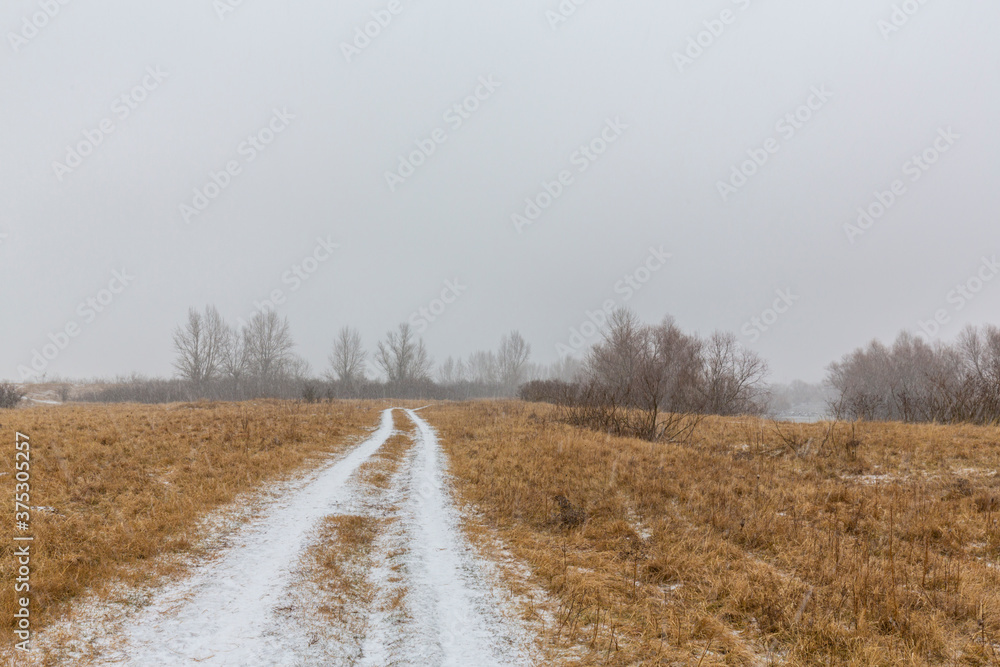 Naklejka premium Fresh powder snow covering a windy country road, in winter